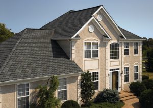 A two-story home features a brick exterior and a black, dimensional apshalt shingle roof.